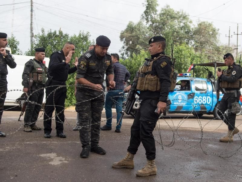 Sicherheitskräfte bringen einen Stacheldraht vor einem Wahllokal in Bagdad an. Foto: Meng Tao/XinHua