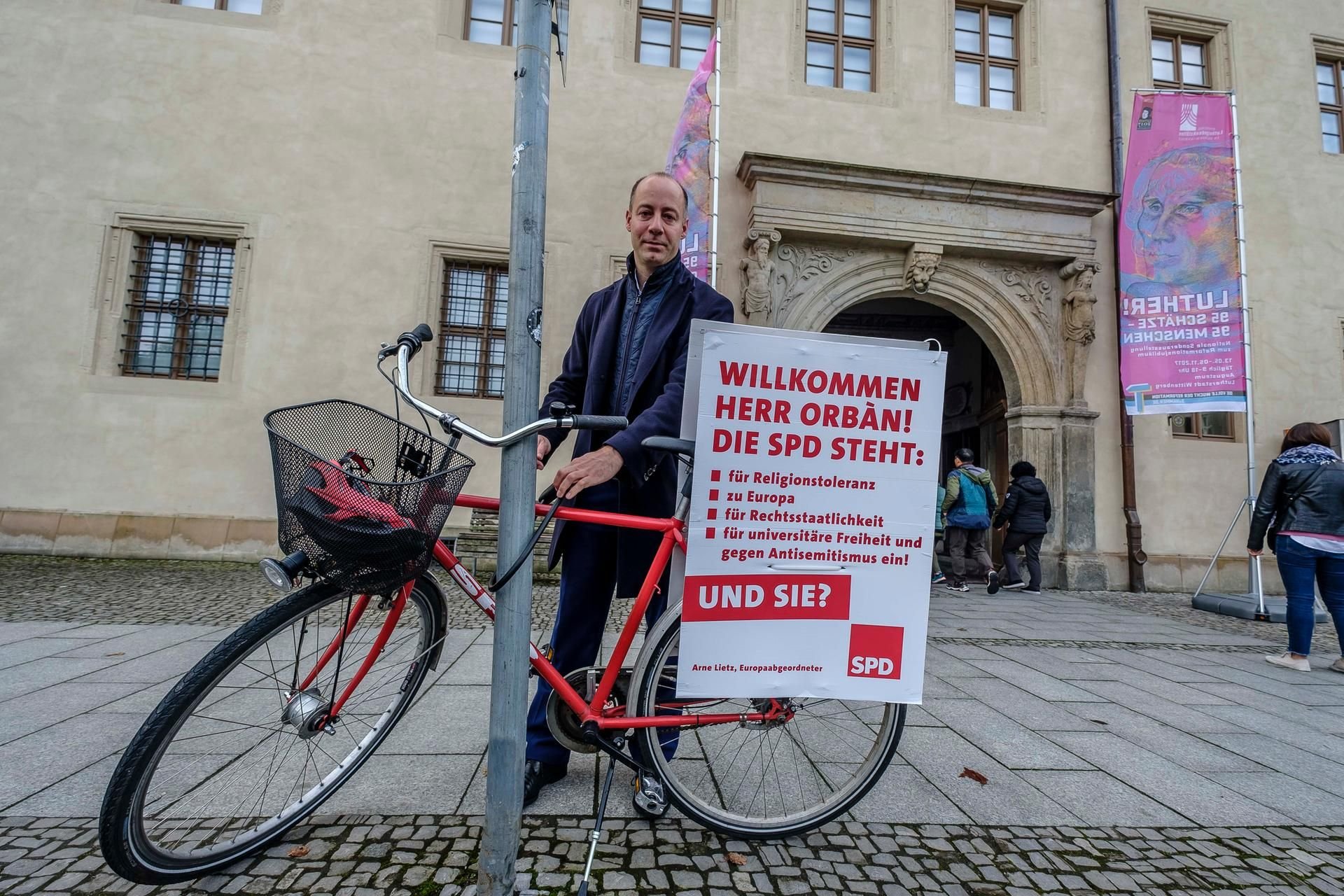 Der SPD-Politiker Arne Lietz protestiert mit einem Plakat gegen den Besuch von Ungarns Ministerpräsident Viktor Orban.