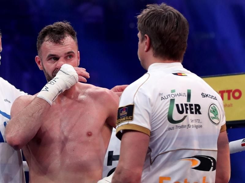Dominic Bösel (M) steht nach seiner Niederlage mit Trainer Dirk Dzemski (r) in der Ringecke. Foto: Ronny Hartmann/dpa-Zentralbild/dpa