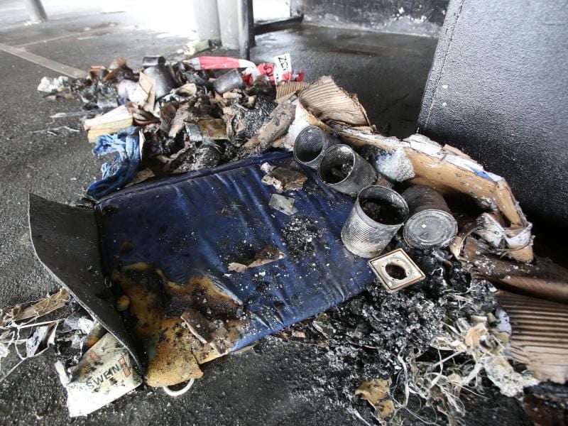 Angebrannte Gegenstände an der Schlafstätte der beiden Obdachlosen auf einem Parkdeck an den St.Pauli-Landungsbrücken in Hamburg. Foto: Bodo Marks
