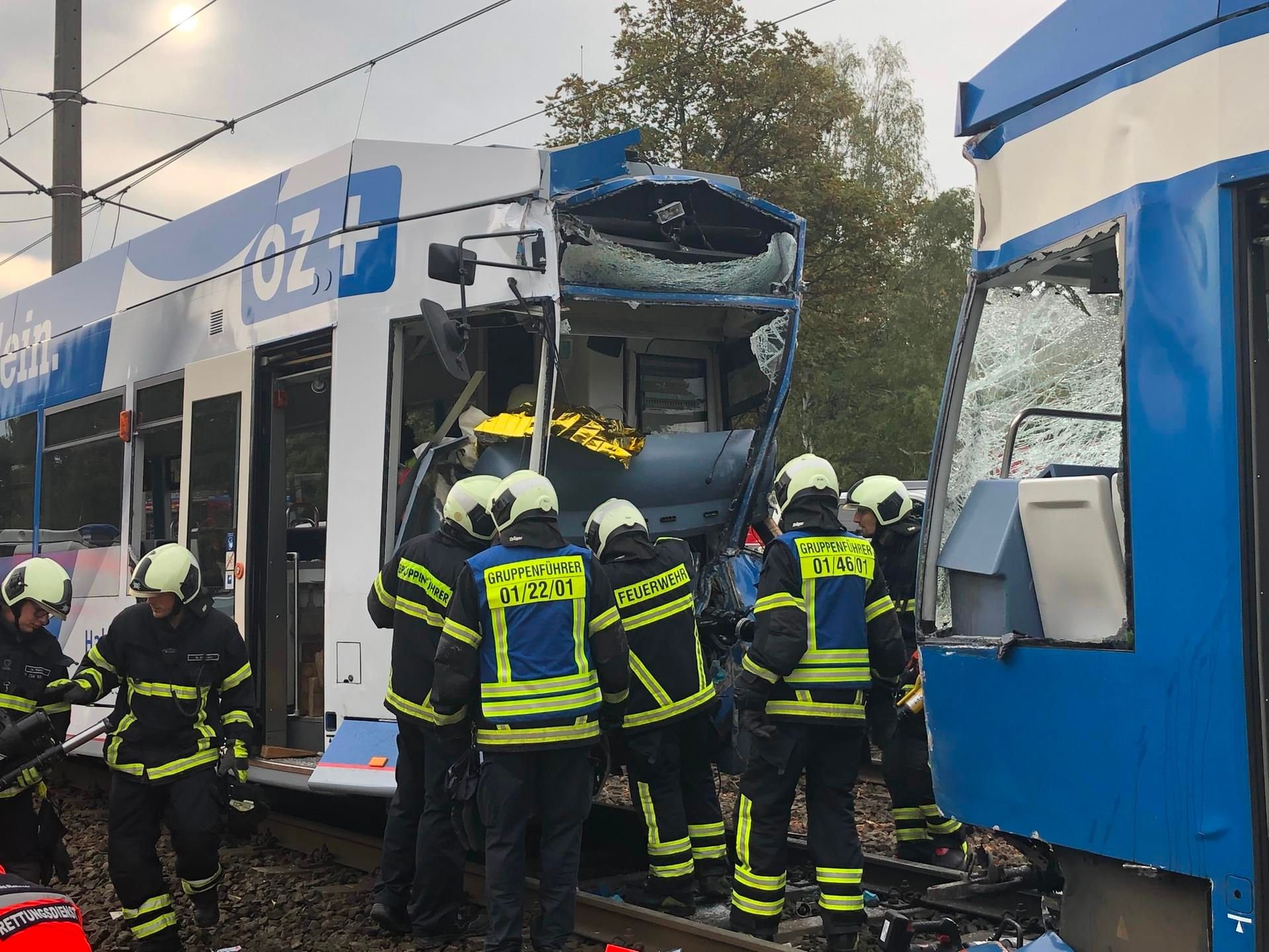 Rostock: Einsatzkräfte der Feuerwehr arbeiten nach einer Straßenbahnkollision am Unfallort.