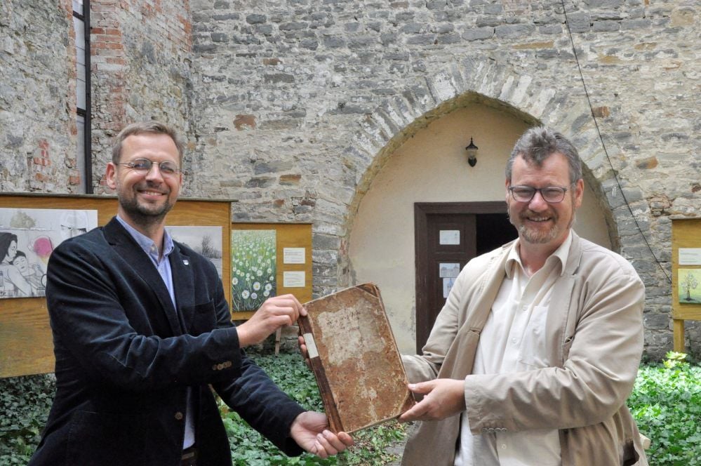 Freuen sich riesig über das gut erhaltene Kirchenbuch: Pfarrer Dankmar Pahlings (re.) und Landeskirchenarchivar Jan Brademann.