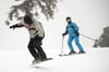 Wintersportler fahren eine Skipiste im Harz hinunter. 