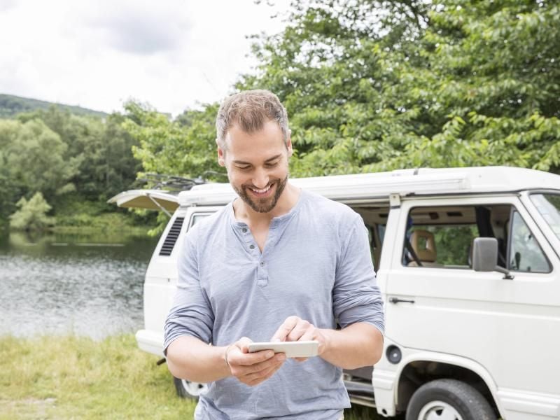 Wo passt der Bully hin? Gibt es dort Strom? Und wie wird das Camping-Wetter? All diese Fragen moderner Camper kann das Smartphone beantworten. Foto: Jo Kirchherr/Westend61/dpa-tmn