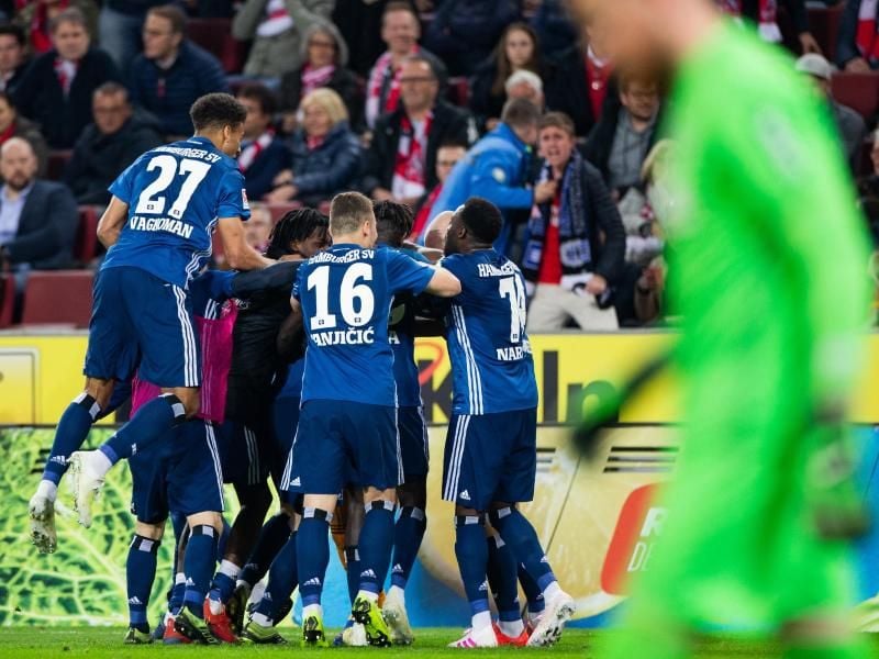 Die HSV-Spieler feiern mit einer Jubeltraube den Treffer von Manuel Wintzheimer (verdeckt) zum 1:1 in Köln. Foto: Rolf Vennenbernd/dpa