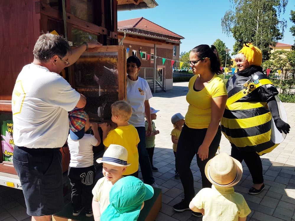 In der Tagesstätte „Villa Teige“ feierten die Kinder und ihre Erzieher am Dienstag ein Bienenfest. Zu Gast war die Bienenkönigin Peggy Knöffel (rechts). Sie erklärte den Kleinen viel über den Stachel der Tiere. Am Wagen der Imkerei Puppe konnten sich die Kinder die echten Bienen anschauen.