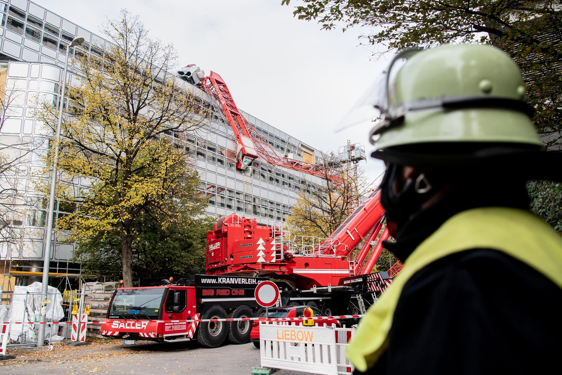 München: Der Ausleger eines umgestürzten Baukrans lehnt an einer Hauswand.