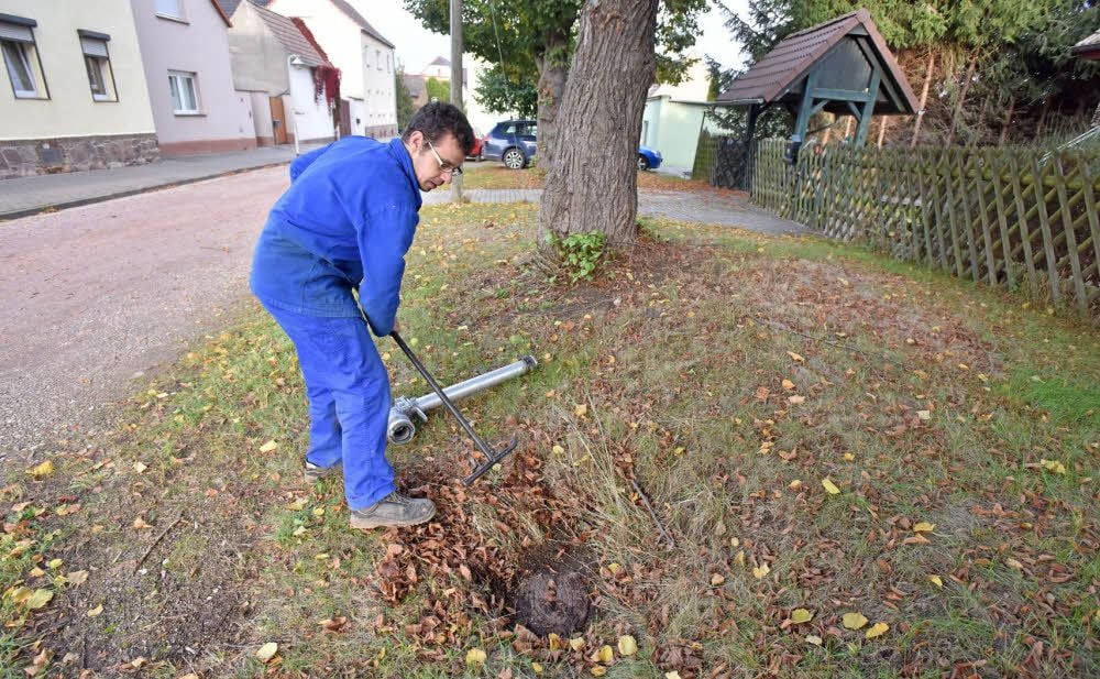 Man muss schon sehr genau hinsehen: Das Wadendorfer Feuerwehrmitglied Tobias Ortel befreit im Ort einen Hydranten vom Laub.