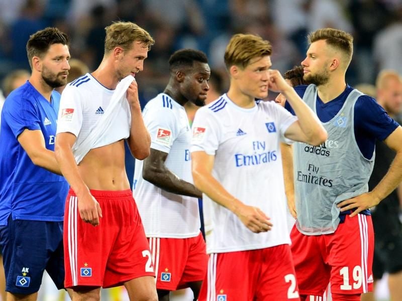 Hamburgs Spieler gehen nach den 0:3-Niederlage gegen Holstein Kiel niedergeschlagen vom Platz. Foto: Daniel Bockwoldt