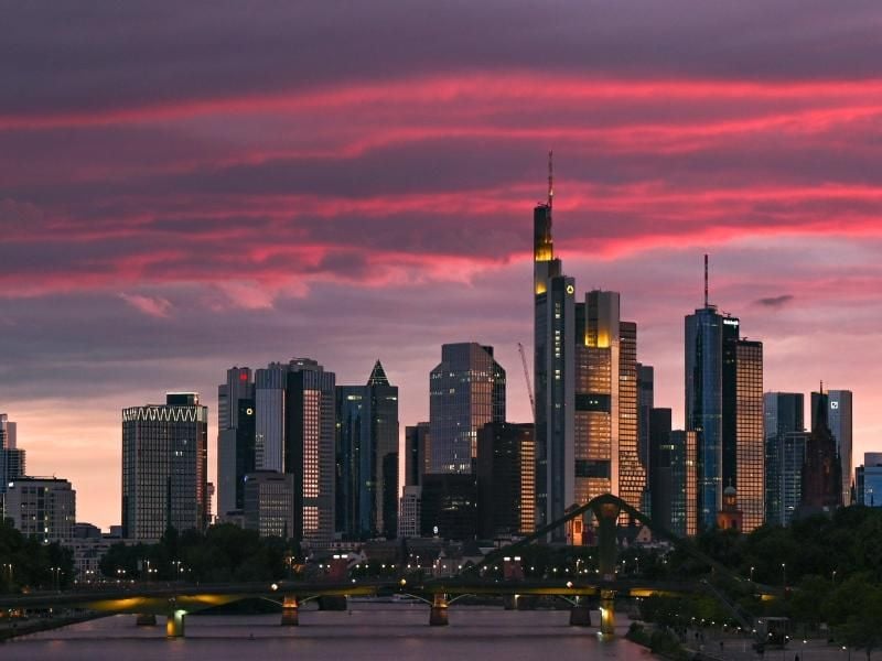 Bei Sonnenuntergang ist die Skyline der Bankenstadt in rötliches Licht getaucht. Foto: Arne Dedert/dpa
