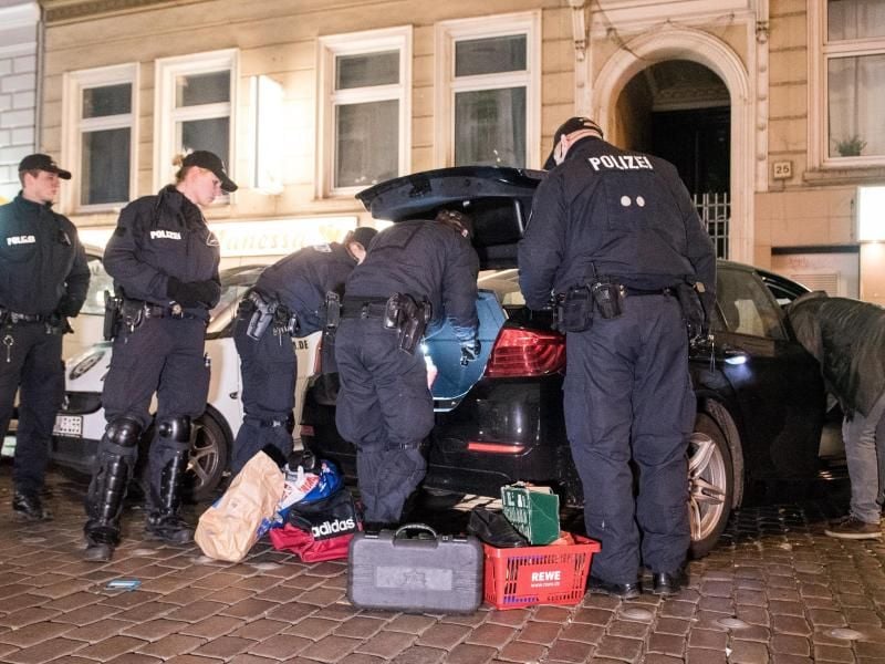 Polizisten durchsuchen ein Auto. Foto: Daniel Bockwoldt