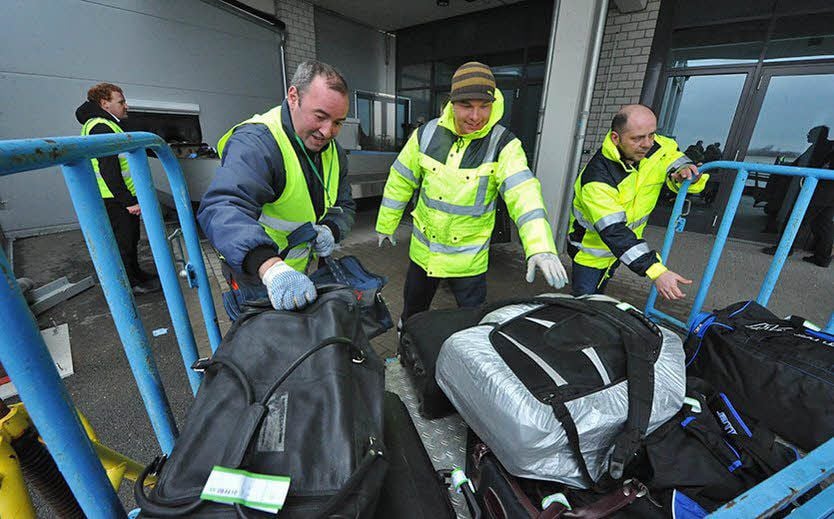 Flughafen-Mitarbeiter kümmern sich in Cochstedt um das Gepäck.