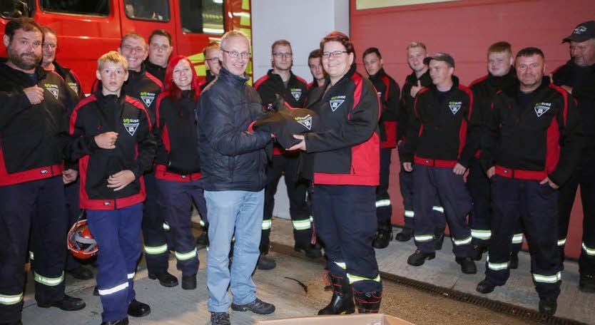 Frank Weigel von der Suez-Anlage übergibt eine der Jacken an Nadja Kabisch, die stellvertretende Leiterin der Ortsfeuerwehr Zorbau-Gerstewitz.