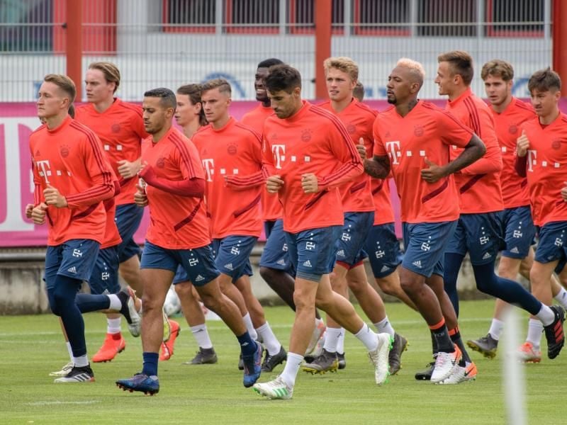 Die Spieler vom FC Bayern München wärmen sich beim ersten öffentlichen Training an der Säbener Straße auf. Foto: Matthias Balk