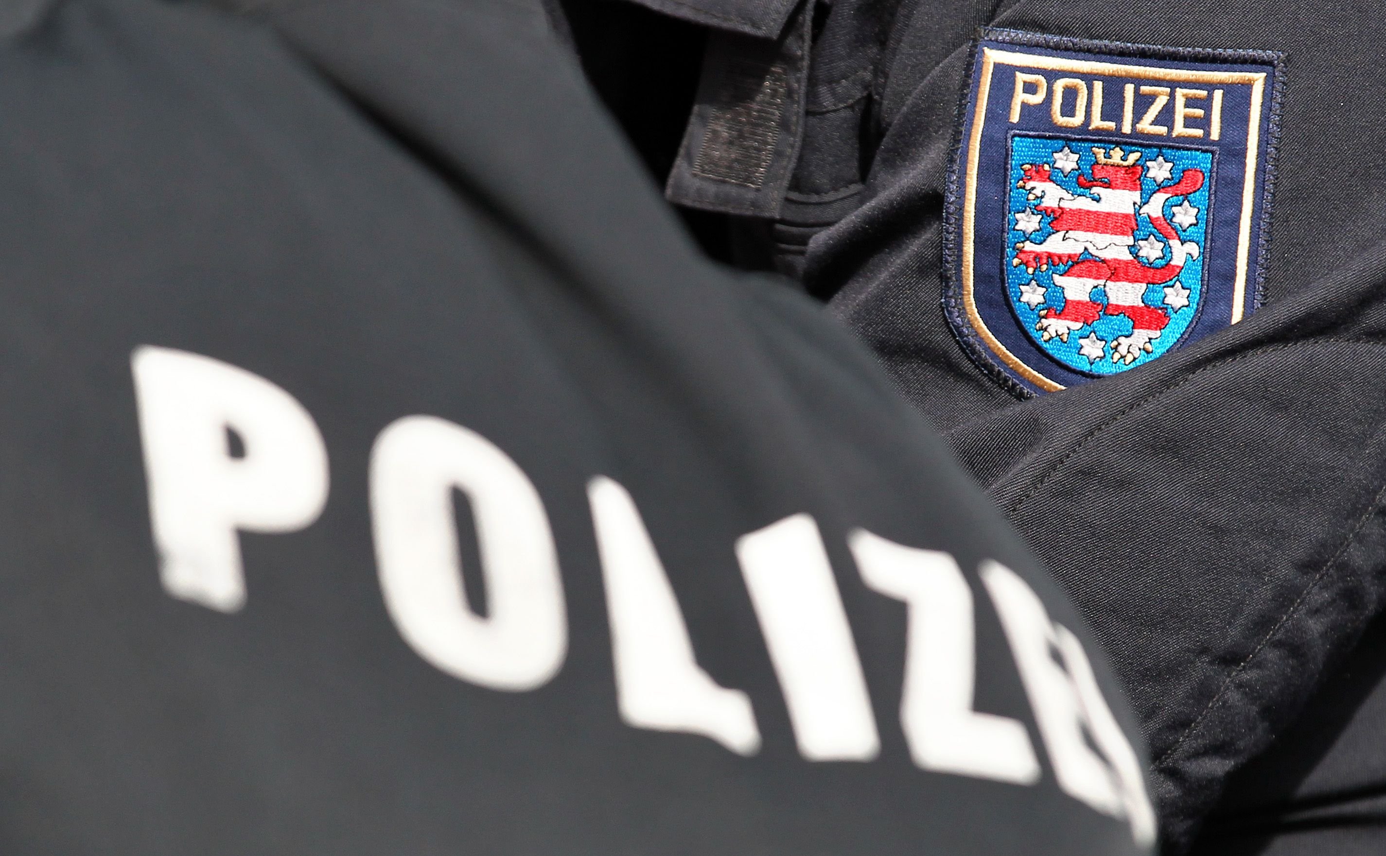 Der Schriftzug «Polizei» und das Logo von Thüringen stehen auf den Uniformen von zwei Polizeibeamten