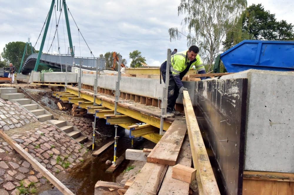 Mario Gieloff nimmt die Schalung von Betonteilen der Brücke ab.