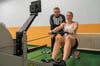 „Trockentraining“ auf dem Ruderergometer in Halle - hier schafft sich Julia Lier nahezu täglich. Trainer Frank Köhler beobachtet die Szenerie.