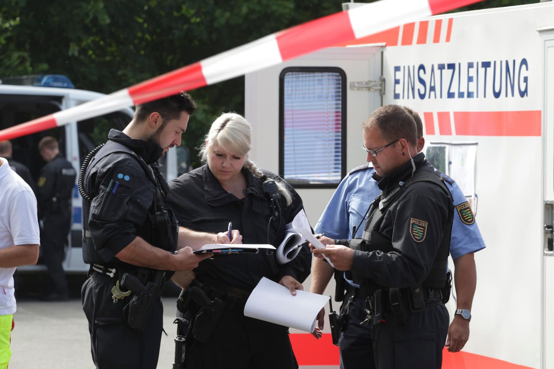 Plauen: Polizeibeamte besprechen sich in der Nähe des Bomben-Fundorts vor dem Fahrzeug der Einsatzleitung.