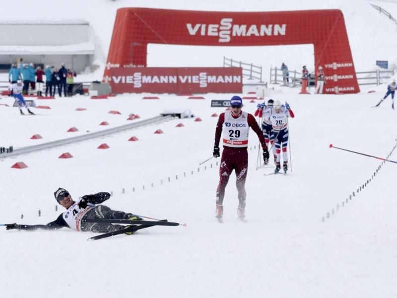 Der Schweizer Dario Cologna (l) liegt nach dem Zielleinlauf auf dem Boden. Foto: Berit Roald/NTB scanpix
