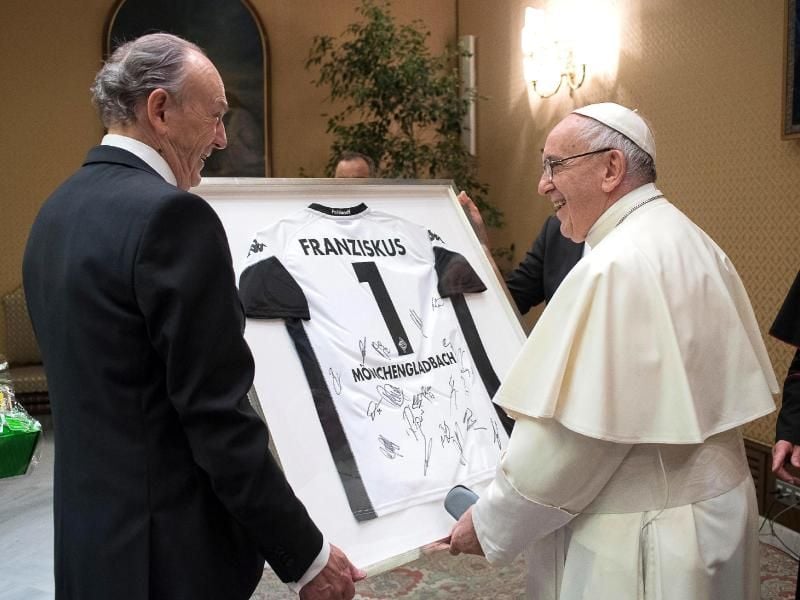 Borussia Mönchengladbachs Präsident Rolf Königs überreicht Papst Franziskus ein Gladbach-Trikot. Foto: L'Osservatore Romano/dpa