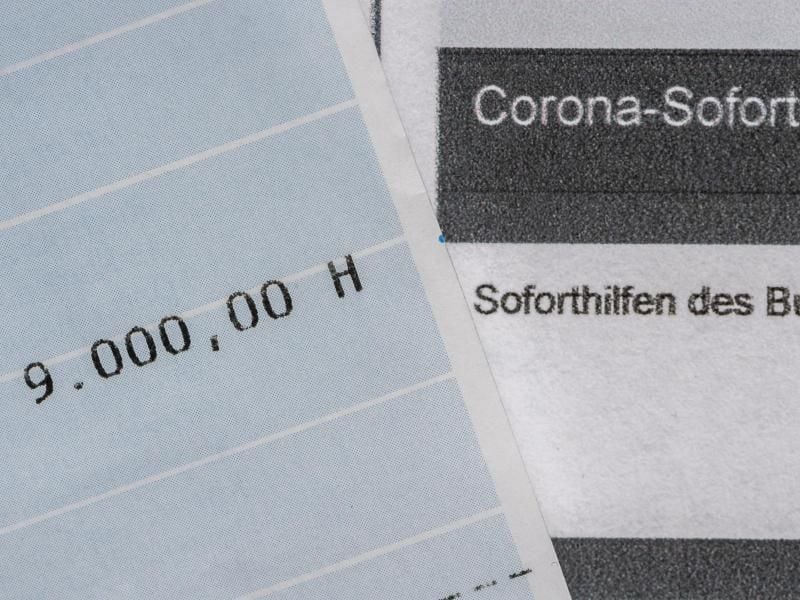 Ein Kontoauszug mit der überwiesenen Summe von 9.000 Euro Corona-Soforthilfe liegt auf einem Antrag für den Zuschuss der Sächsischen Aufbaubank. Foto: Robert Michael/dpa-Zentralbild/dpa