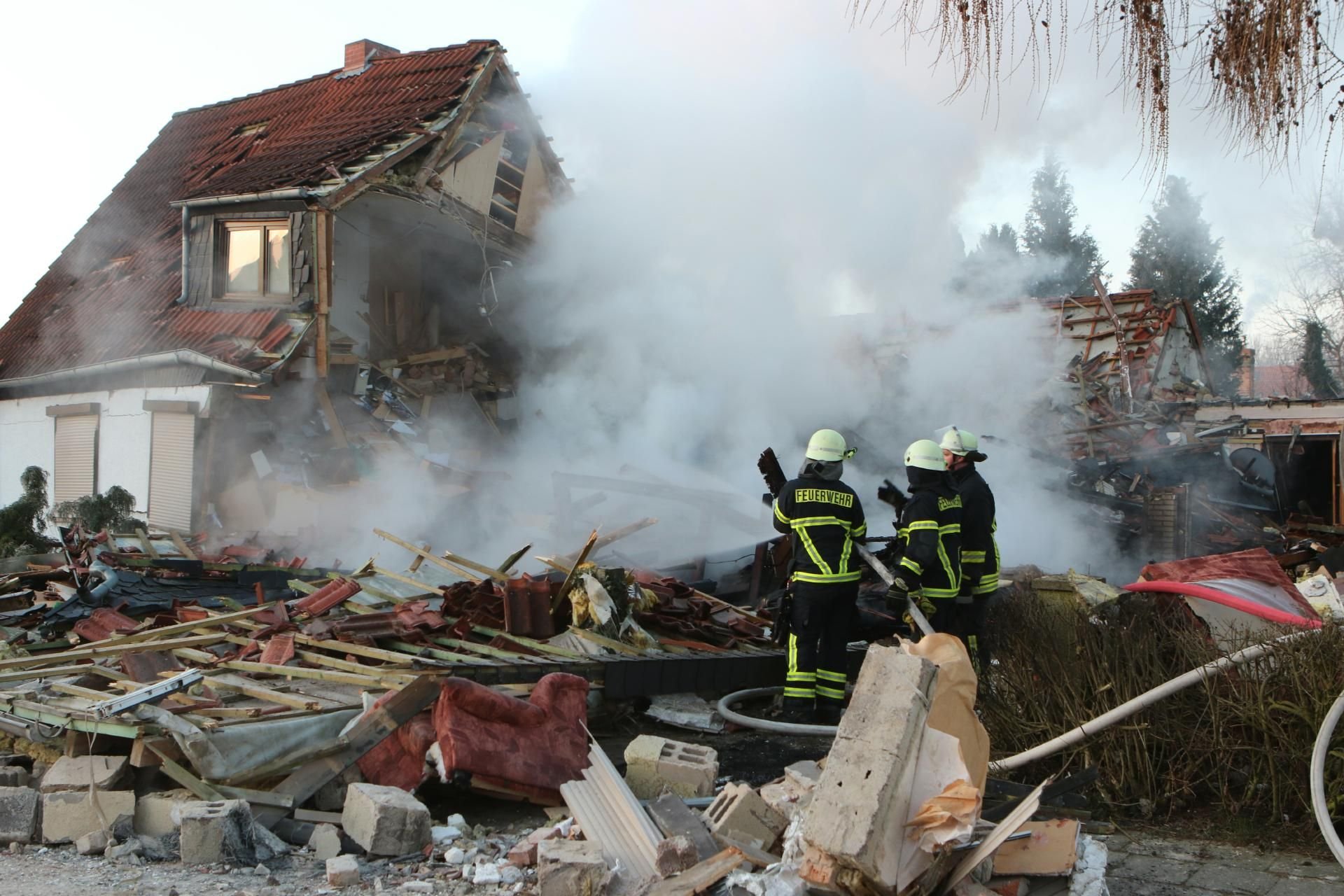Feuerwehrleute stehen am 23. Februar nach der Explosion der Doppelhaushälfte vor den Trümmern in der Gartenstadt in Halberstadt.