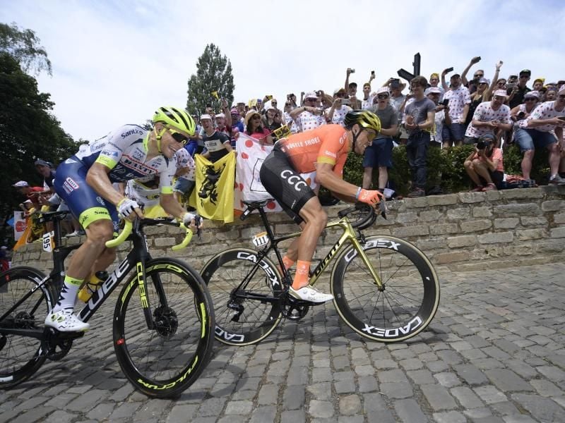 Zahlreiche Zuschauer feiern die beiden Lokalmatadoren Xandro Meurisse (l) und Greg Van Avermaet auf dem belgischen Kopfsteinpflaster. Foto: Yorick Jansens/BELGA