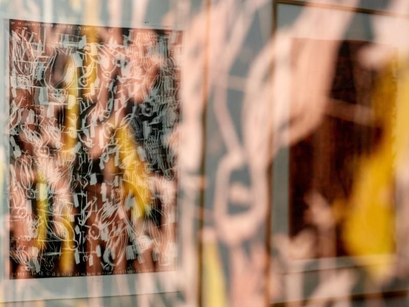 Zwei Holzschnitte aus der Serie „Ciao America” von Georg Baselitz spiegeln sich in der Verglasung über einem dritten Bild der Serie. Foto: Bernd Thissen