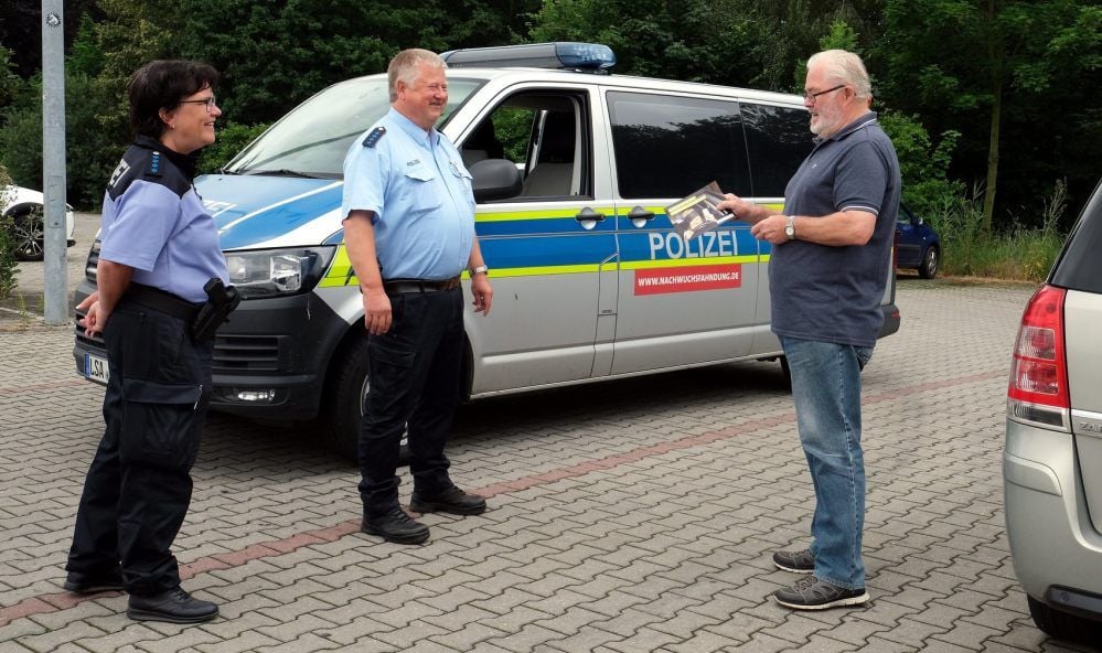 Die Polizisten Irina Richter und Frank Befeld sprechen in Draschwitz mit Autofahrer Frank Reichenbach über das Thema Ablenkung.