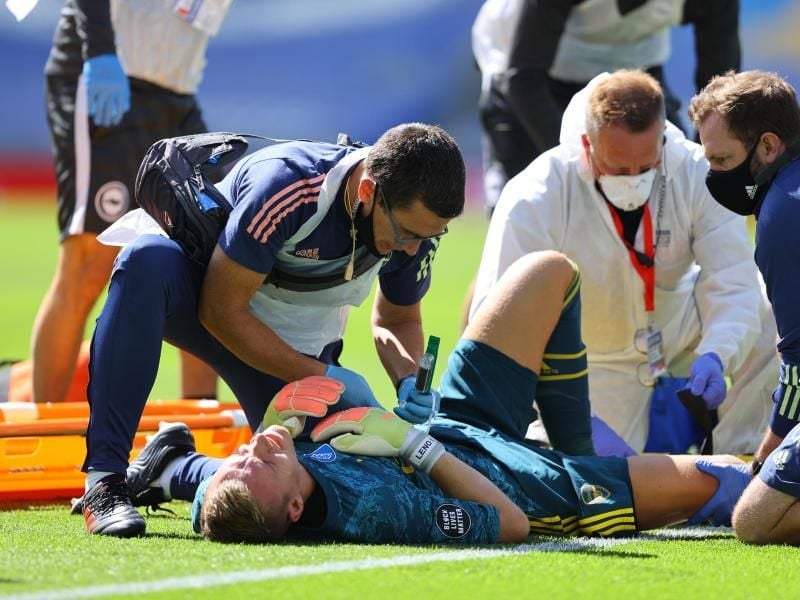 Arsenal-Torwart Bernd Leno (M) wird von medizinischem Personal behandelt, nachdem er sich verletzt hat. Foto: Richard Heathcote/Nmc Pool/PA Wire/dpa