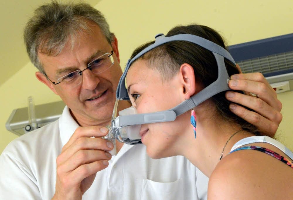 Arzt Steffen Schädlich passt eine Maske an, die Atemaussetzer verhindert.
