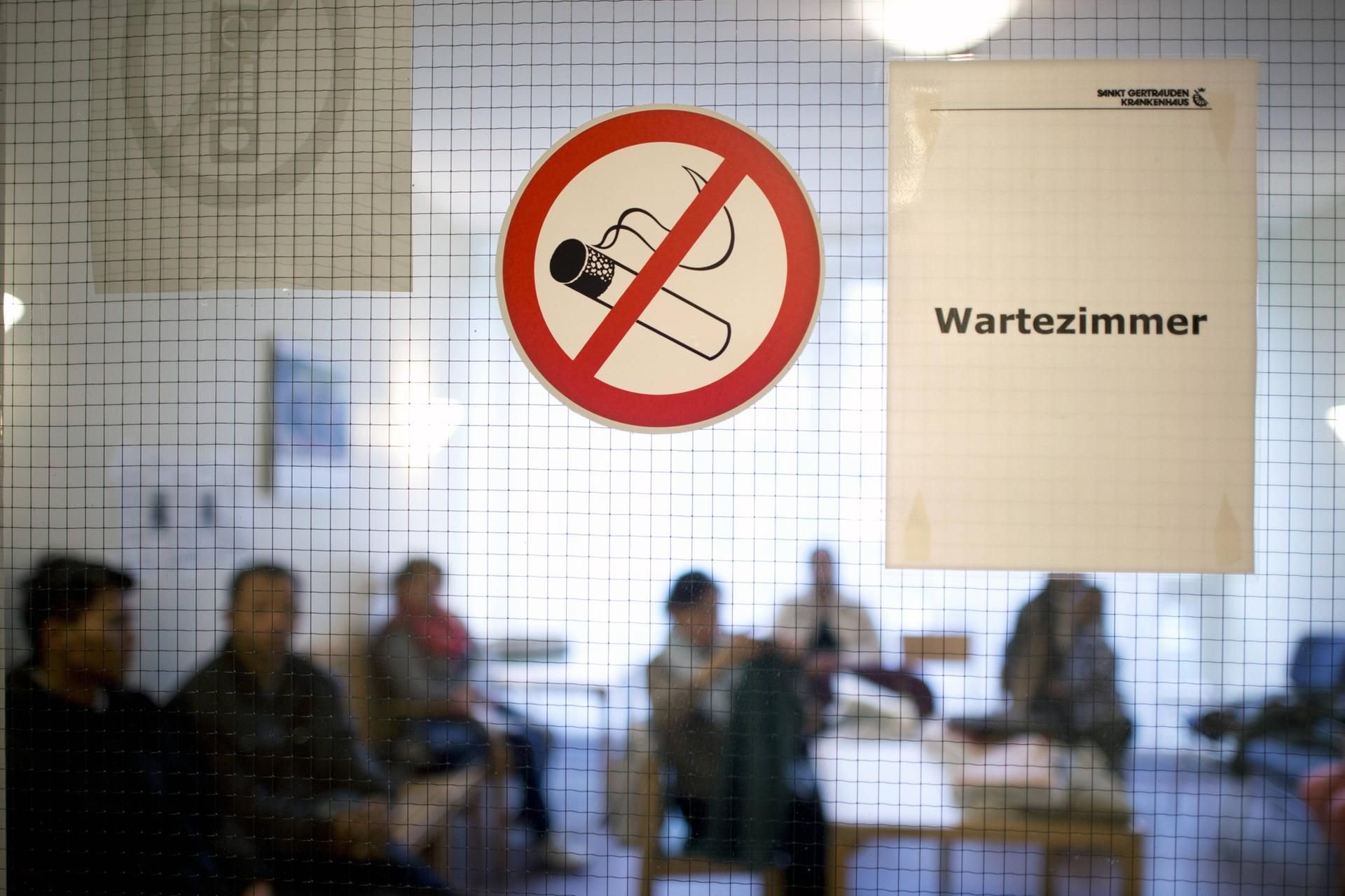 Patienten sitzen im Wartezimmer eines Krankenhauses und warten auf Behandlung.