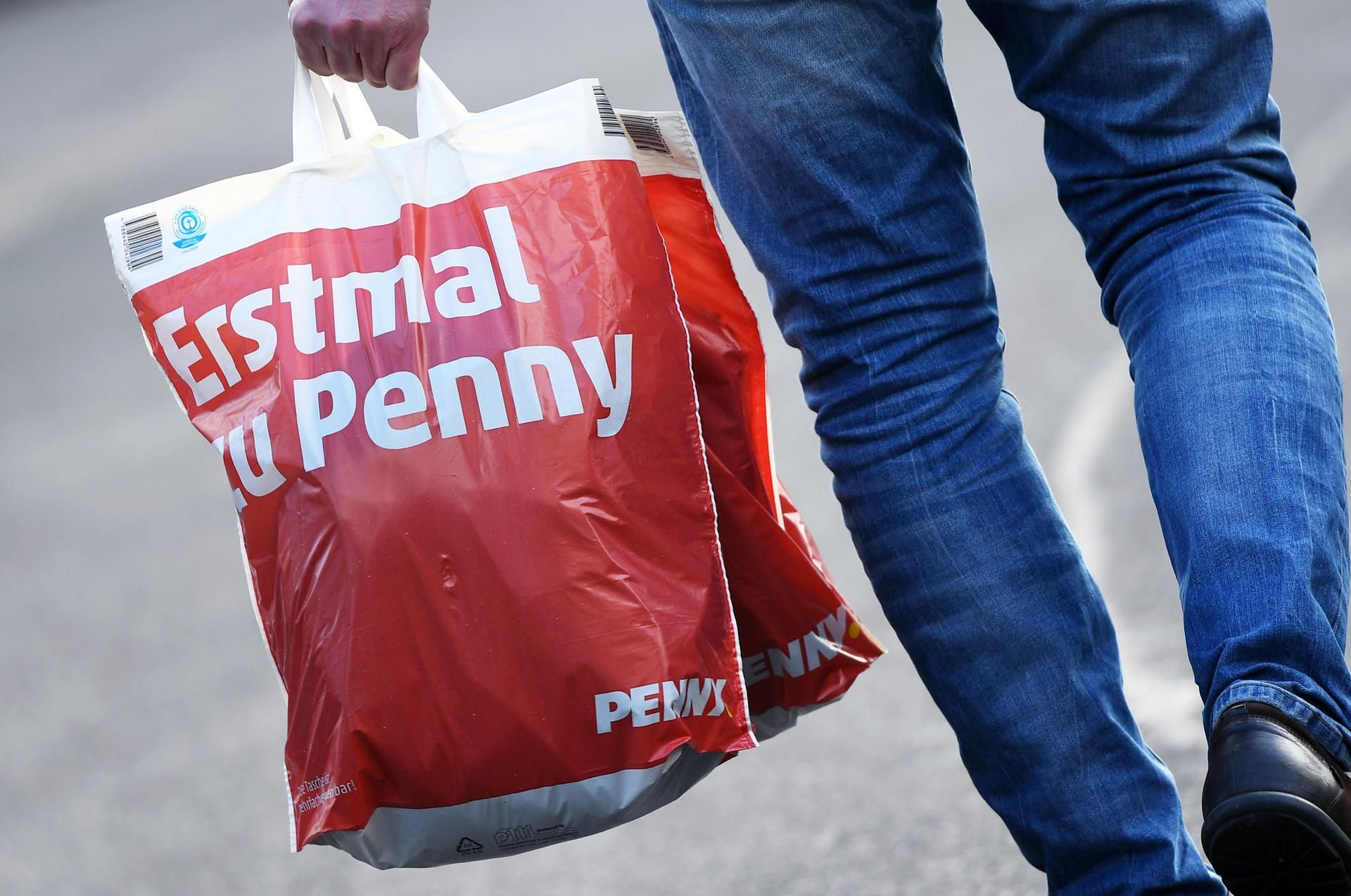 Ein Mann trägt eine gefüllte Plastiktüte von Penny. (Symbolbild)
