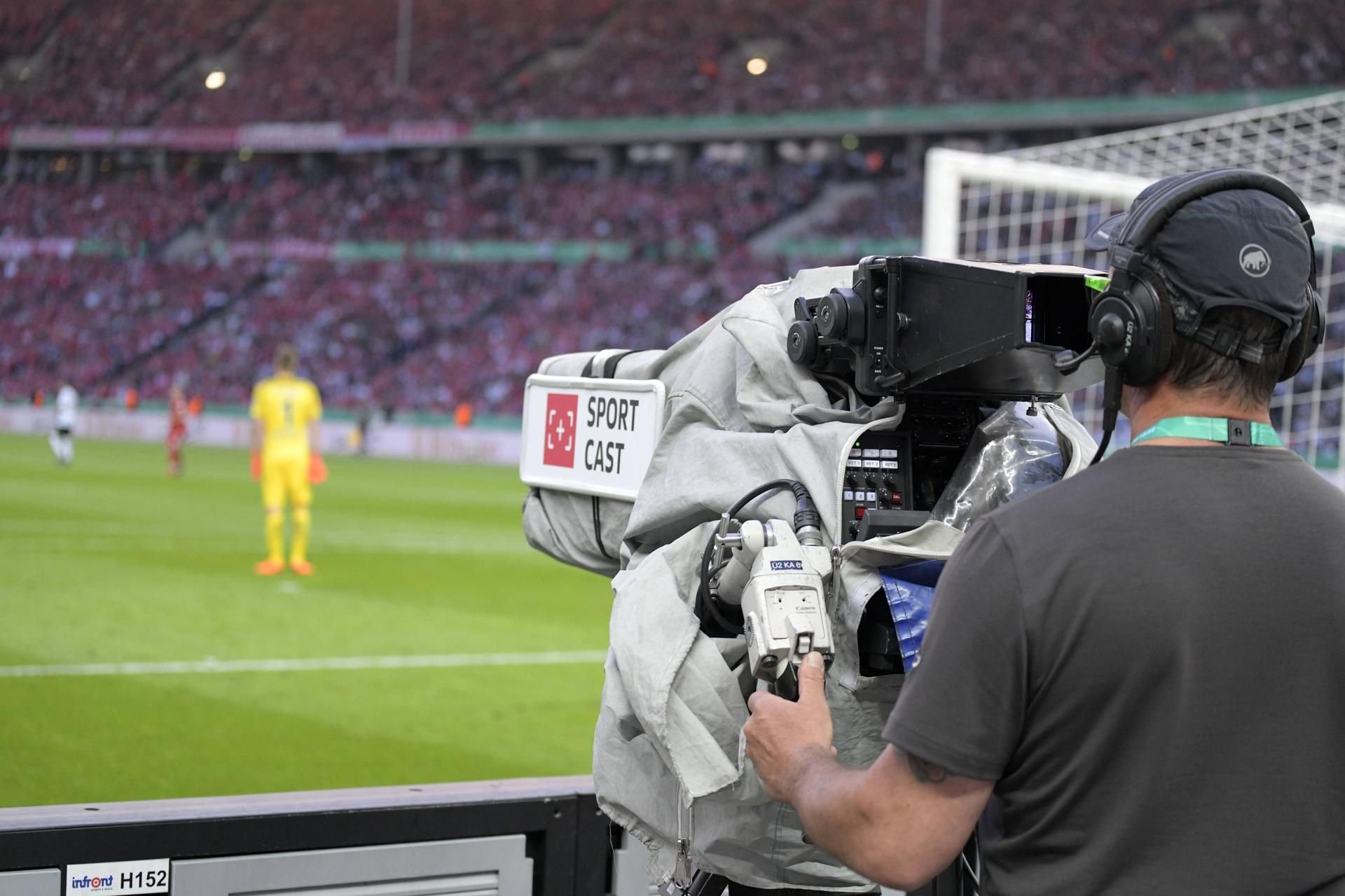 Ein Kameramann bei einer Live-Übertragung eines Fußball-Spiels.