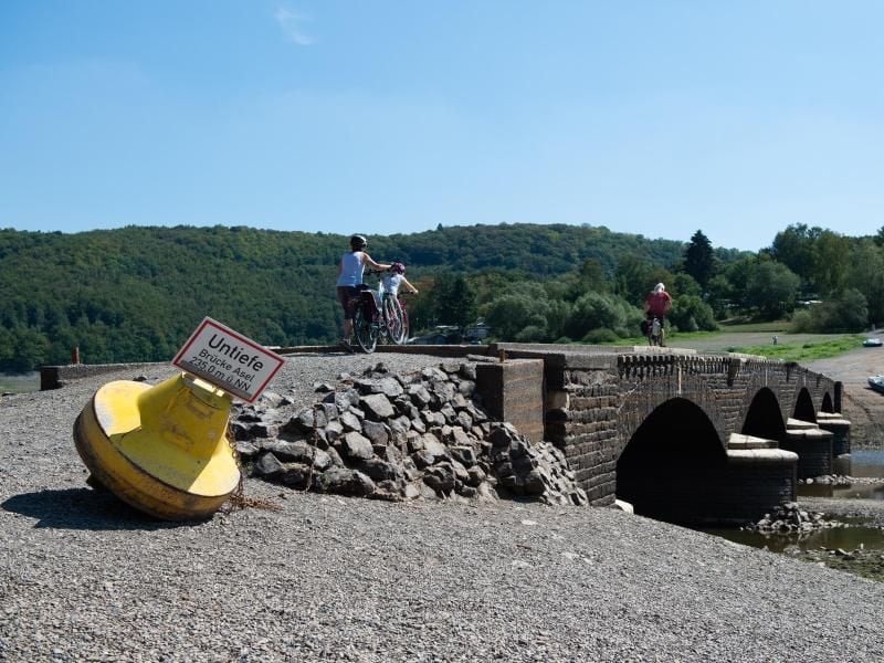 Radfahrer fahren über die alte Aseler Brücke im Edersee. Foto: Swen Pförtner