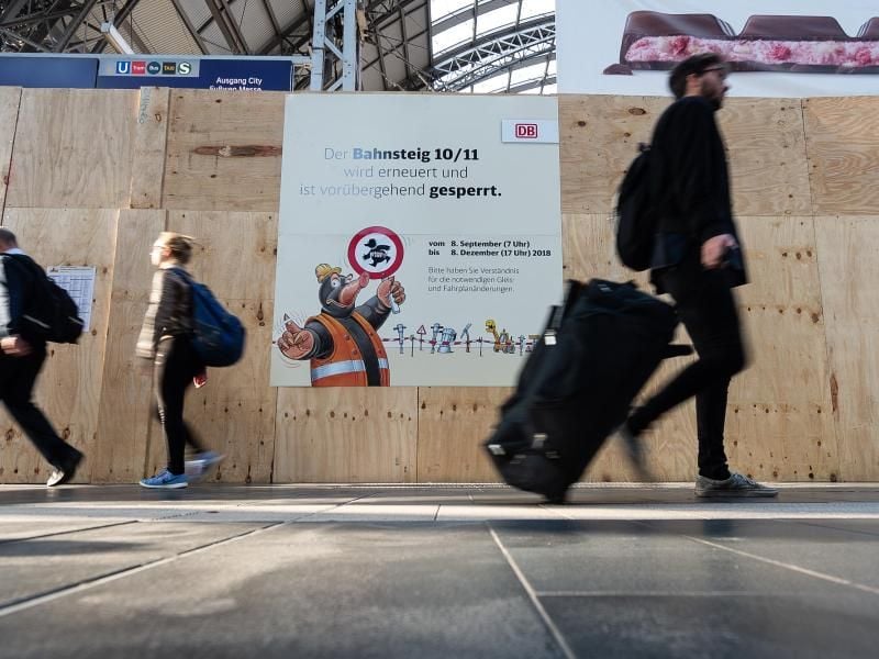 Reisende gehen an der Baustelle der Bahnsteige 10 und 11 im Frankfurter Hauptbahnhof vorbei. Foto: Silas Stein