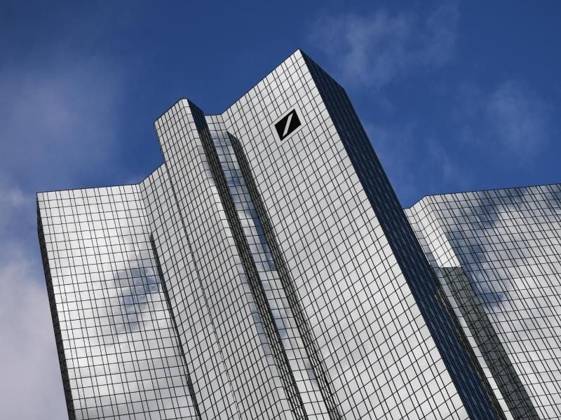 Wolken spiegeln sich in der Fassade der Zentrale der Deutschen Bank. Foto: Arne Dedert/dpa/Symbolbild