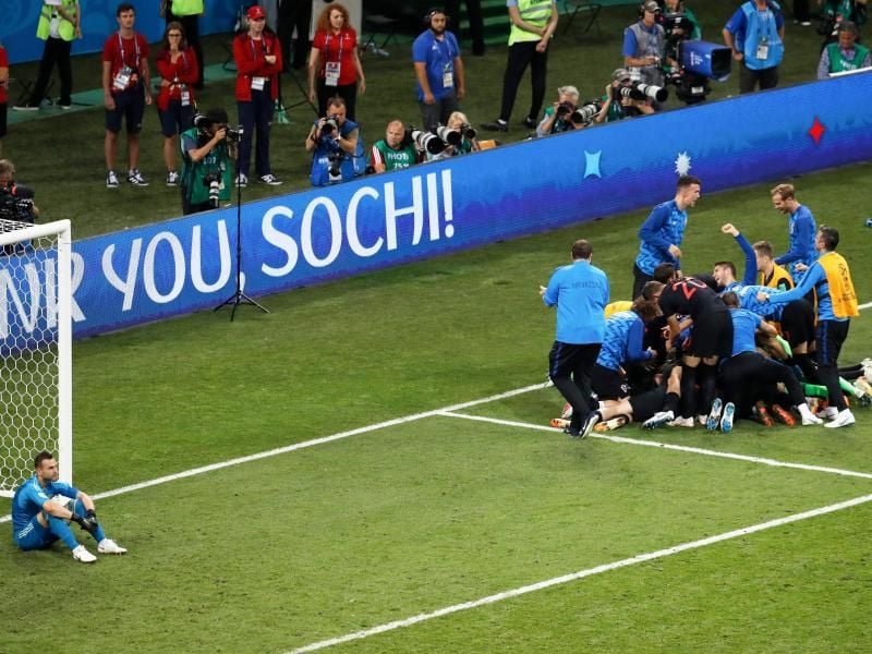 Nach dem Sieg im Elfmeterschießen begraben die kroatischen Spieler ihren treffsicheren Torschützen Ivan Rakitic in einer Jubeltraube unter sich. Links sitzt der geschlagene russische Torhüter Igor Akinfejew. Foto:&nbsp;Alexander Zamlianichenko/AP