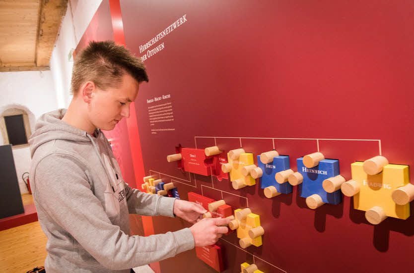Cedric Kloß probiert ein interaktives Puzzle aus, das das Herrschernetzwerk der Ottonen veranschaulicht.