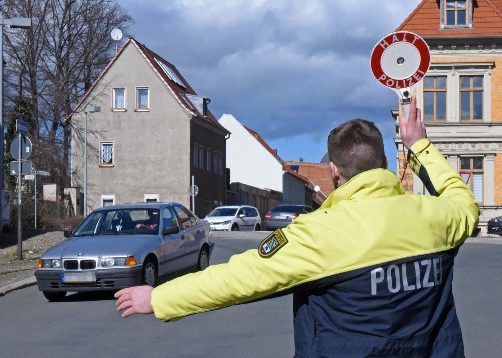 Praktikant Marcel Schnitzer winkt einen BMW in Aschersleben an den Straßenrand.