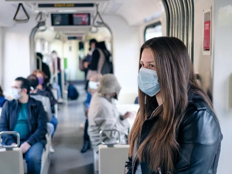 Eine Frau trägt eine Maske in einer Bahn. Foto: Ole Spata/dpa/Symbolbild