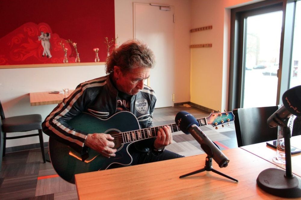 Peter Maffay testet in der Brasserie Lözius in Halle eine Gitarre.