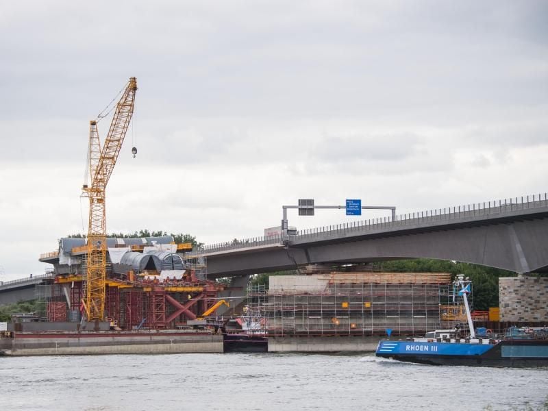 Ein Binnenschiff fährt an der Brückenbaustelle vorbei. Foto: Andreas Arnold/Archivbild