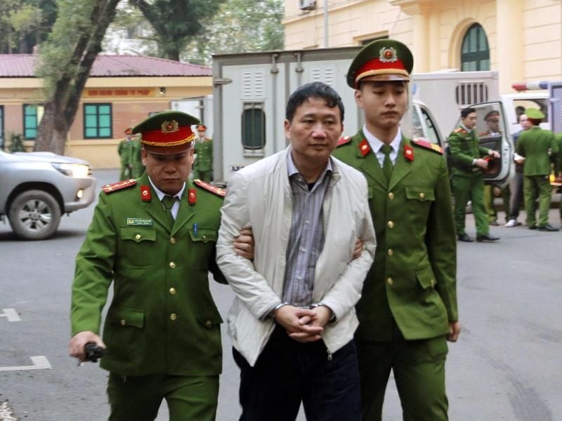 Polizisten bringen den angeklagte Geschäftsmann Trinh Xuan Thanh (M) in ein gericht in Hanoi. Foto: Doan Tan, VNA/AP/dpa