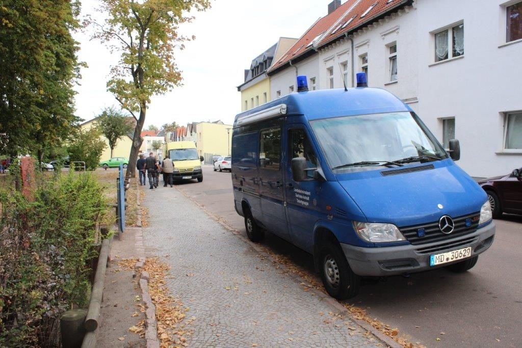 Ein Fahrzeug der Kripo steht in der Nähe des Tatorts am Karlsplatz in Köthen.