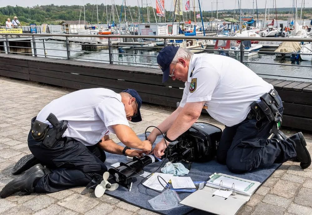 Polizeihauptmeister Ralph Rösiger (l.) und Polizeiobermeister Steffen Franke gravieren einen Bootsmotor.