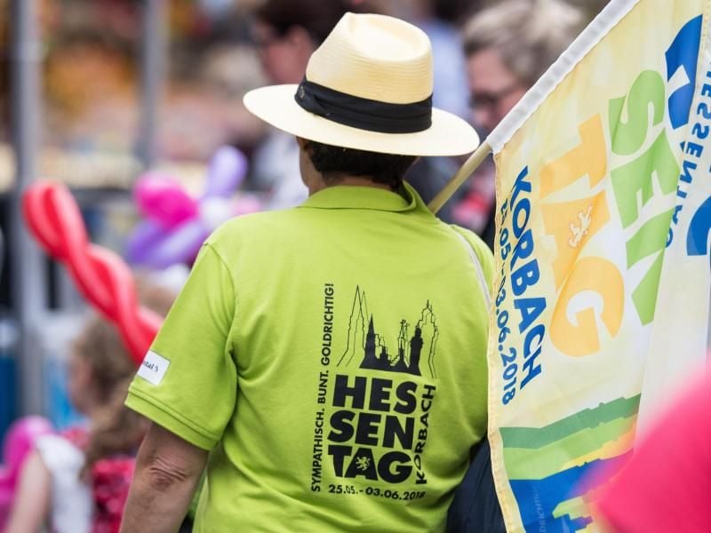 Eine Helferin trägt eine Flagge mit der Aufschrift "Hessentag". Foto: Swen Pförtner