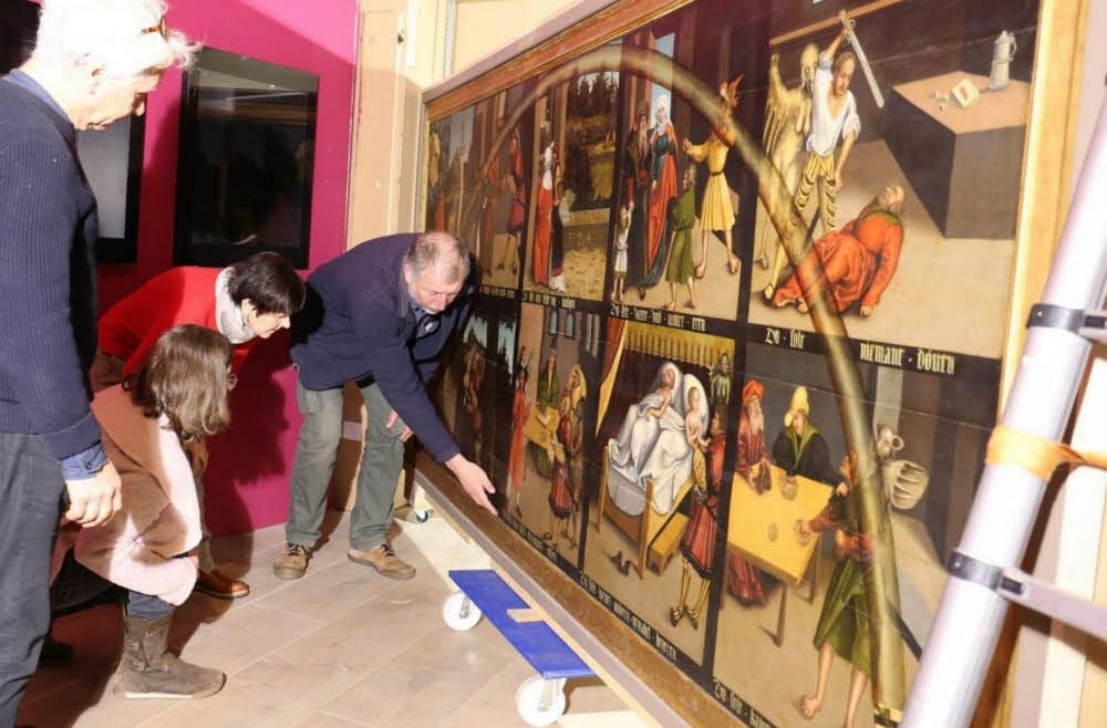 An der Zehn-Gebote-Tafel des Lutherhauses laufen Restaurierungsarbeiten. Restaurator Andreas Mieth erläutert Schäden am Rahmen.