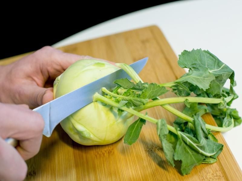 Weg damit: Weil sie dem Kohlrabi die Feuchtigkeit entziehen, sollten die Blätter gleich nach dem Einkauf entfernt werden. Foto: Karolin Krämer/dpa-tmn