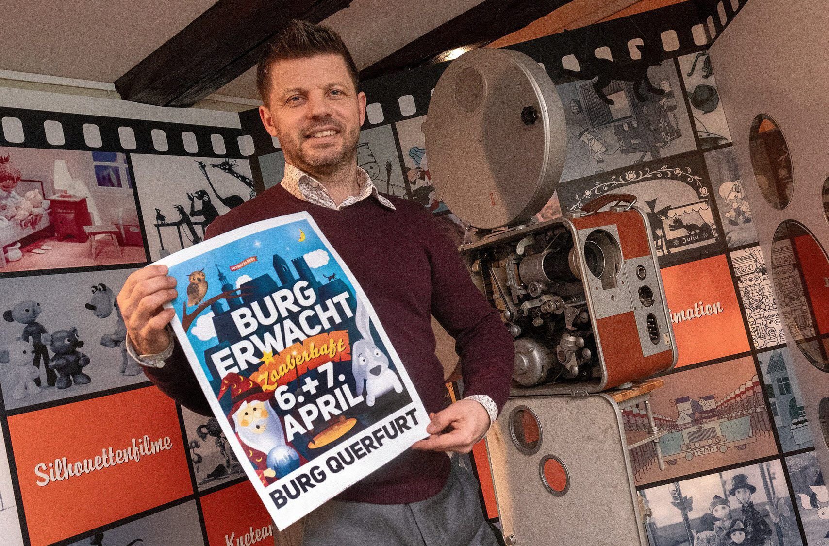 Burgmanager Christian Linke zeigt das Plakat für die Saisoneröffnung „Burg erwacht“, die am 6. und 7. April stattfindet.
